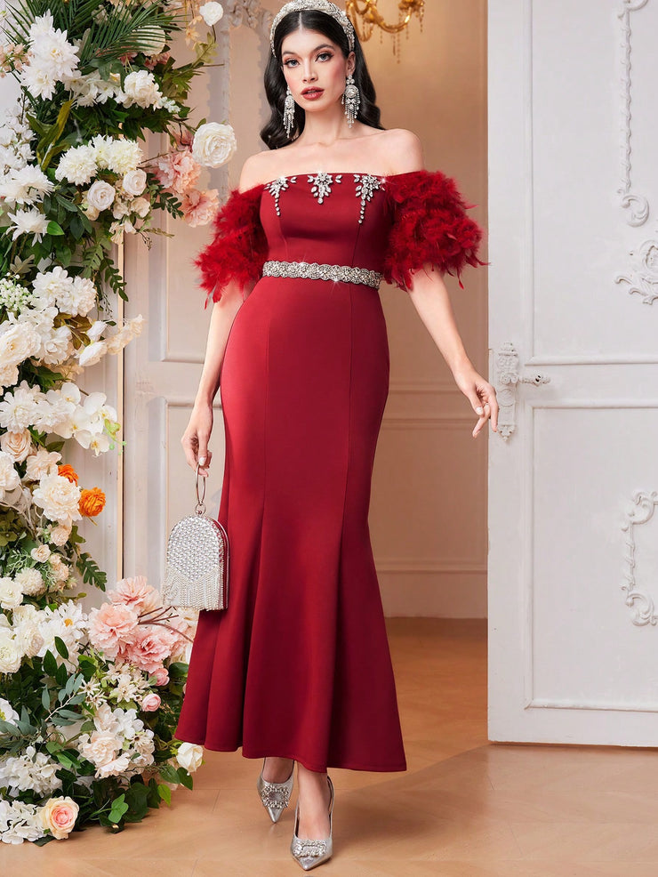Modelyn mermaid dress in burgundy red, adorned with feathers, rhinestones, and beads, without a belt.